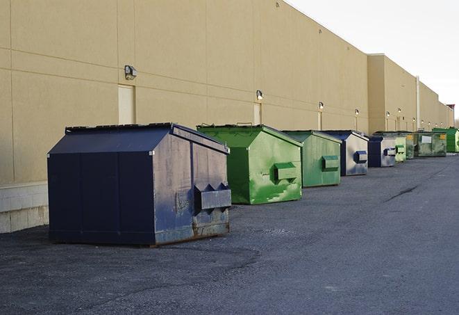 construction workers loading debris into dumpsters on a worksite in Batavia, IA